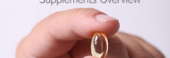 A hand holding a gel pill you could read about on a blog about healthy food and supplements