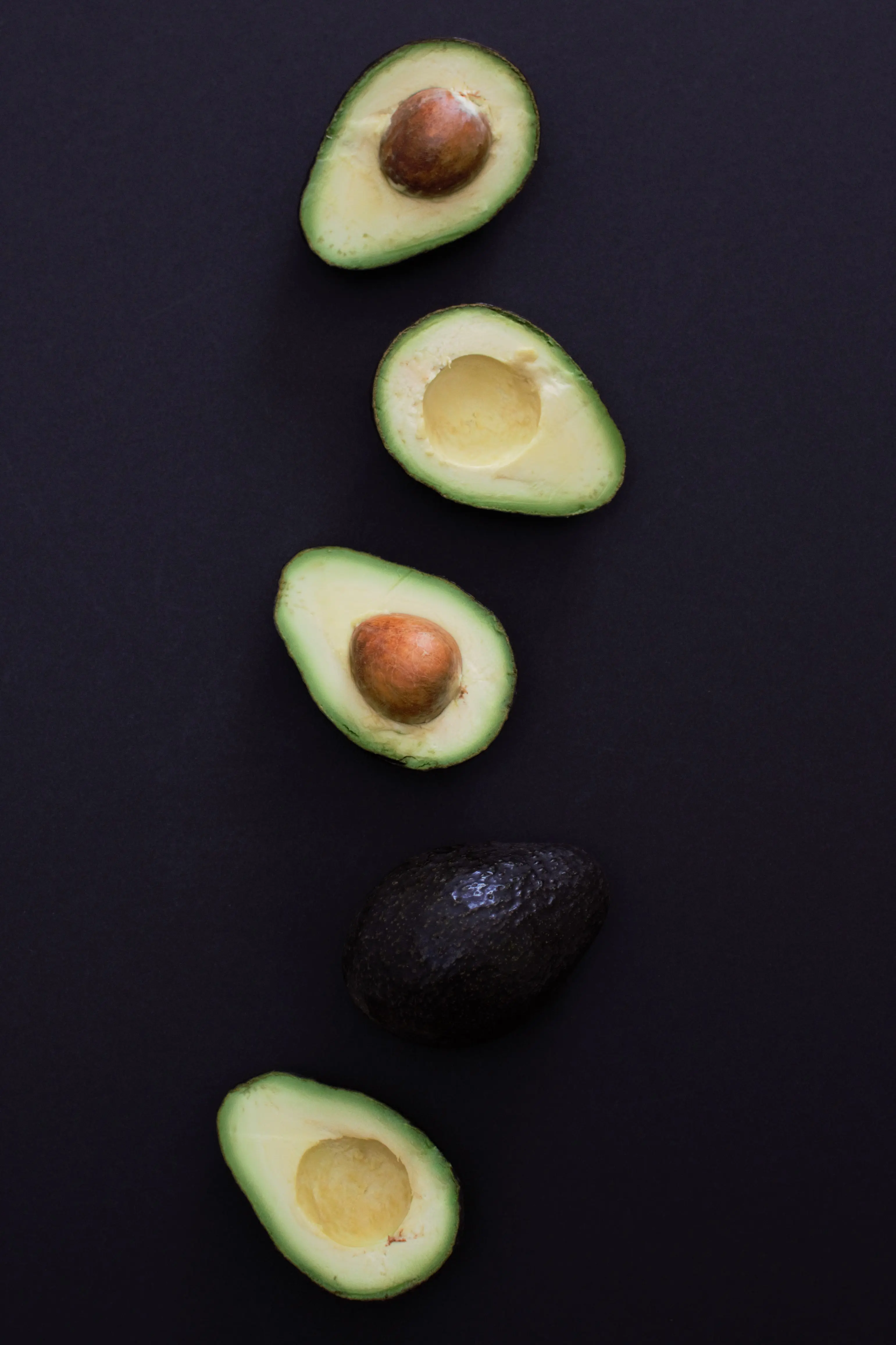 Sliced Avocados on Black Background