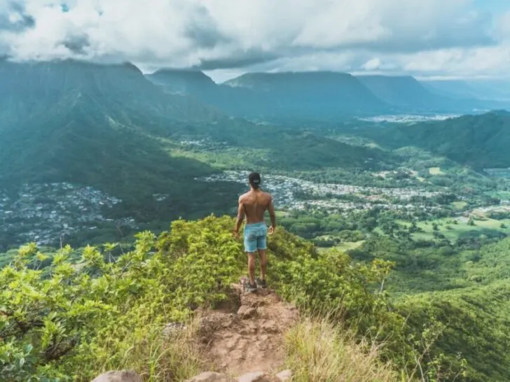 Guy On Top of Mountain With Shirt Off
