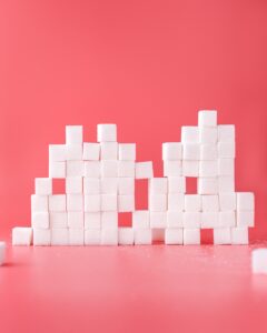 Stack of sugar cubes on pink background