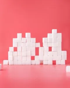 Stack of sugar cubes on pink background