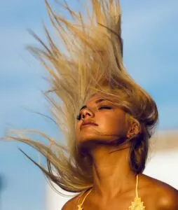 Woman Wearing Yellow Halter Top Whipping Her Hair