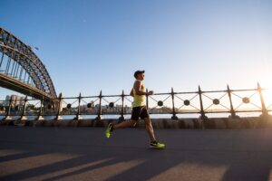 Man in Yellow Tank Top with Glasses Running By River