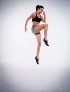 Woman Jumping Near White Wall