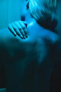 Woman Massaging Back Muscle in Sauna