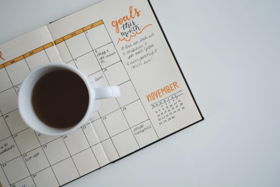 White Ceramic Mug of Coffee on Top of Day Planner