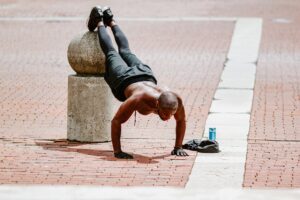 Guy Doing Pushups with Shirt off and Feet On Concrete Ball