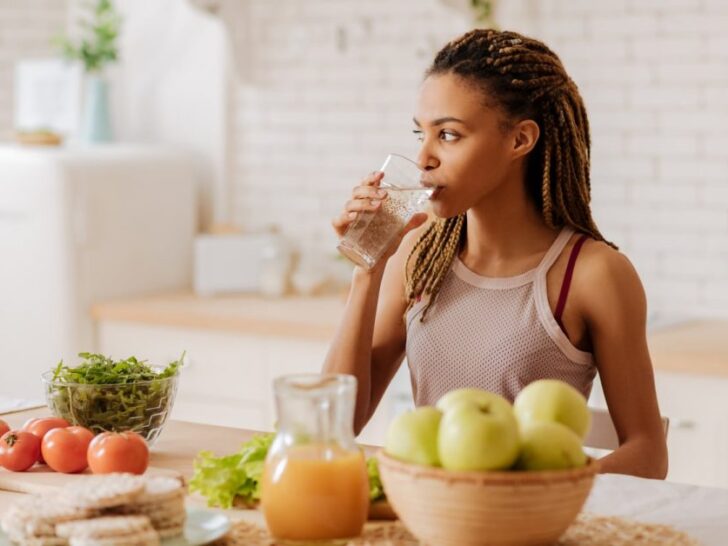 A happy woman eating, as featured on a blog about healthy eating hacks