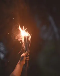 Person Holding Burning Sticks