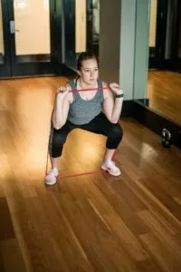 Woman Doing Squats with Resistance Band