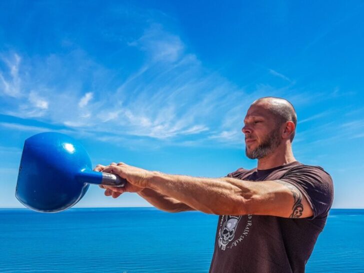 Man Swinging Blue Kettlebell