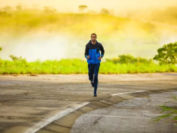 Man in Track Suit Running on Concrete Road