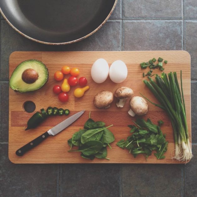 A cutting board with a king and veggies, as featured on a blog about healthy eating hacks