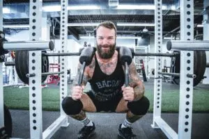 Guy Doing Back Squat Smiling at Bottom of Movement