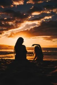 Sunset Picture of Mom and Daughter Doing Yoga on Beach