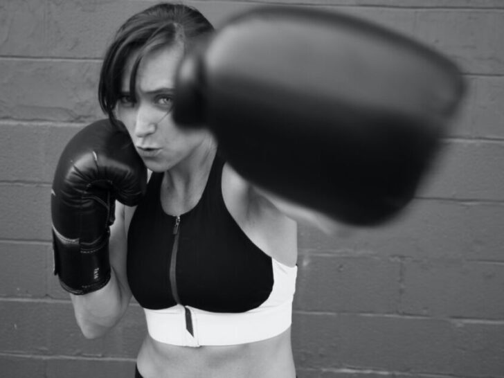 Woman in Boxing Gloves Punching Towards Camera