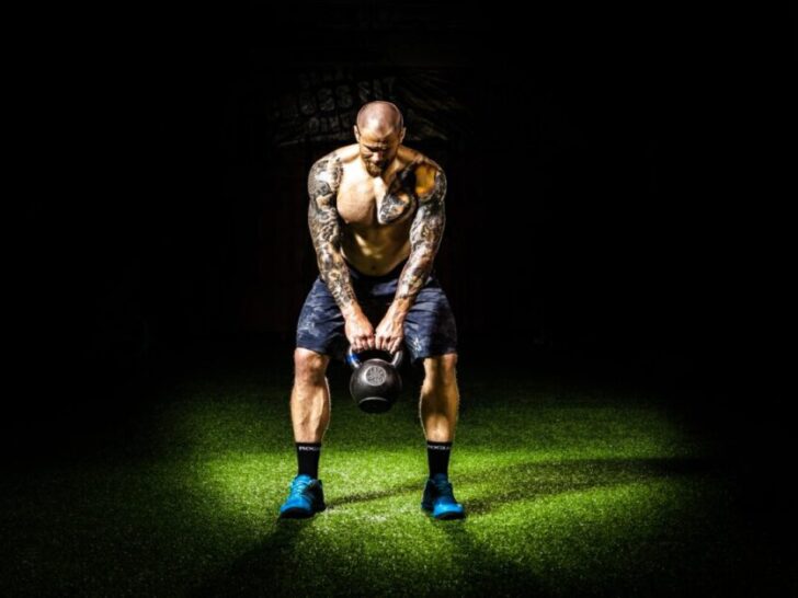 Guy Holding Kettlebell In Spotlight