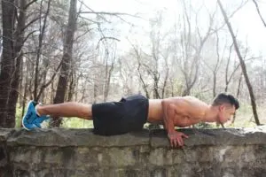 Guy Doing Push Up on Rock Wall Without Shirt