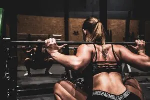 Woman Doing Squat Using Barbell