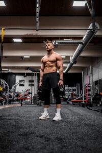 Shirtless Guy Holding Two Kettlebells