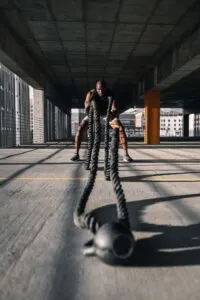 Man Using Battle Ropes with Kettlebell Anchor