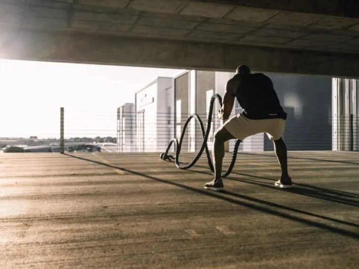 Man Using Battle Ropes in Garage