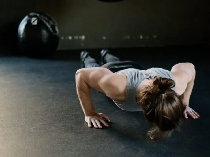 Woman Doing Pushup With Wall Ball In Background