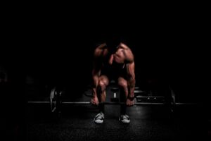 Shirtless Guy in Shadows Doing Barbell Deadlift