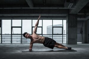 Guy Without Shirt Doing Side Plank with Arm Elevated