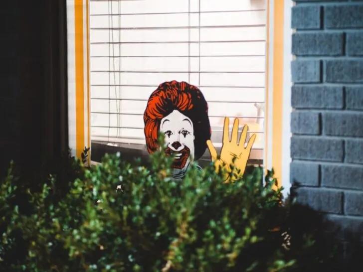 Ronald McDonald Cut Out Waiving from Above Bush