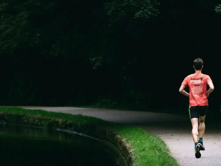 Guy Running Down Road Near Pond Without Headphones