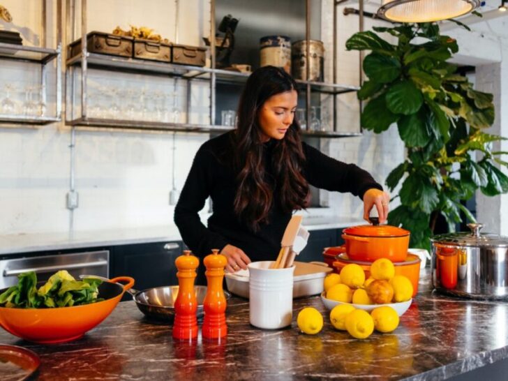 Woman cooking in kitchen with healthy and colorful foods that can be used for losing weight.