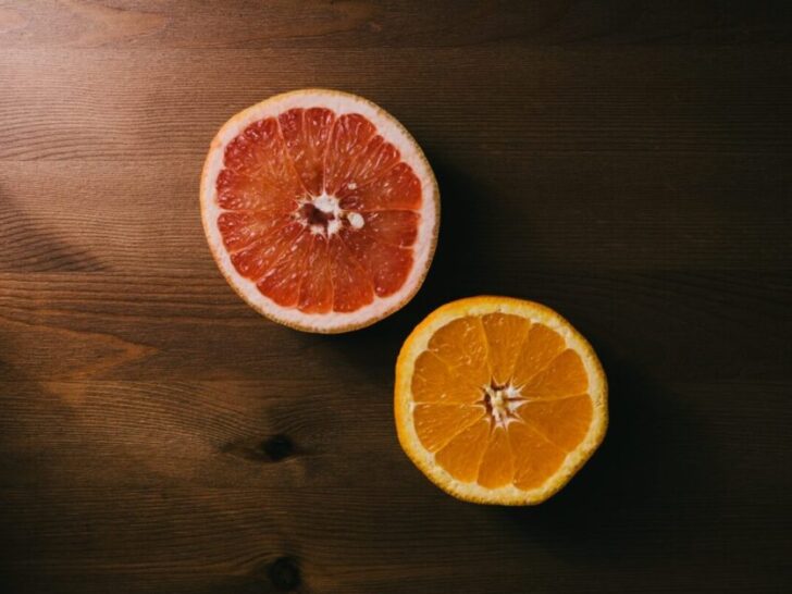 Sliced grapefruit and orange on brown table