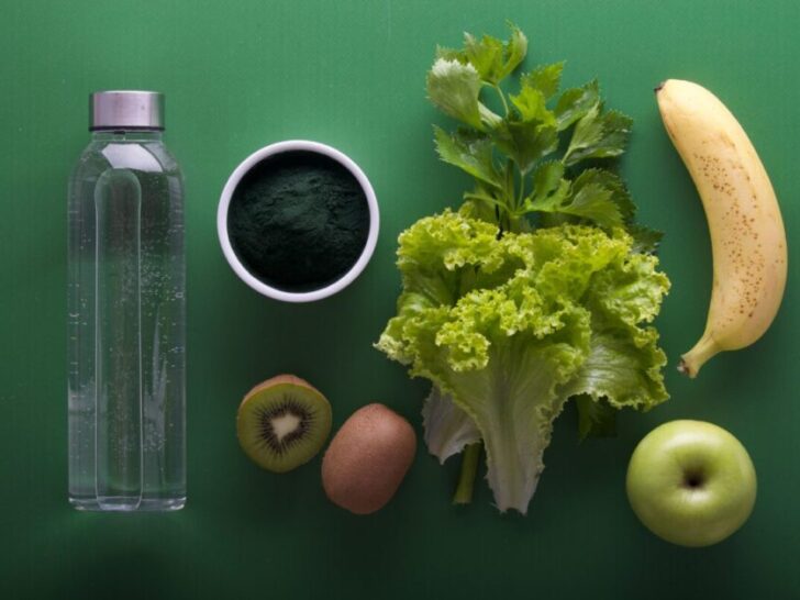 Healthy food and water bottle on green background tools used for biohacking.
